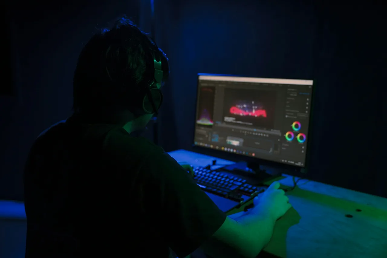 A video editor at a computer in a dark room